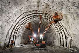 Workers work in a tunnel on the Turin-Lyon railway line using powered access equipment
