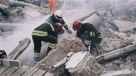 Emergency workers amid the rubble of collapsed buildings