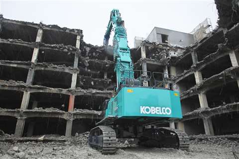 The Kobelco SK1300DLC ultra-high reach demolition machine taking down a tower block
